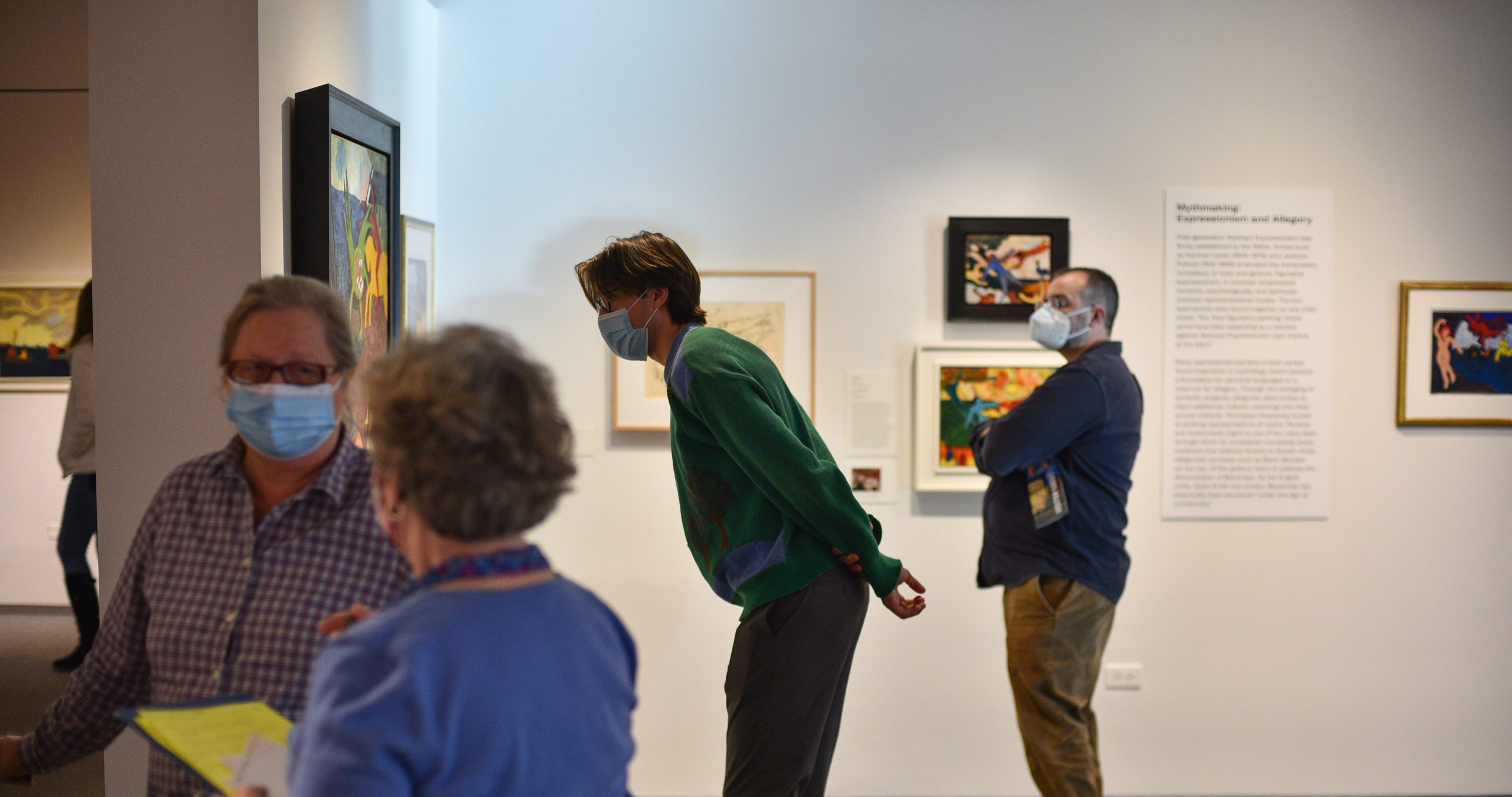 Guy looking at a painting. This is alt text